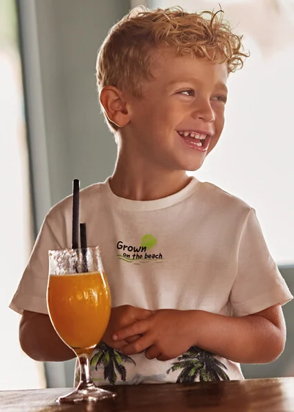 niño camiseta palmeras y zumo en copa